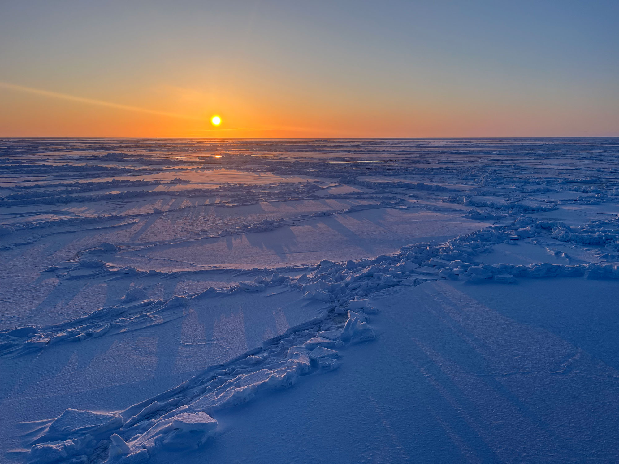 Solnedgang og havis oppdelt i store flak.