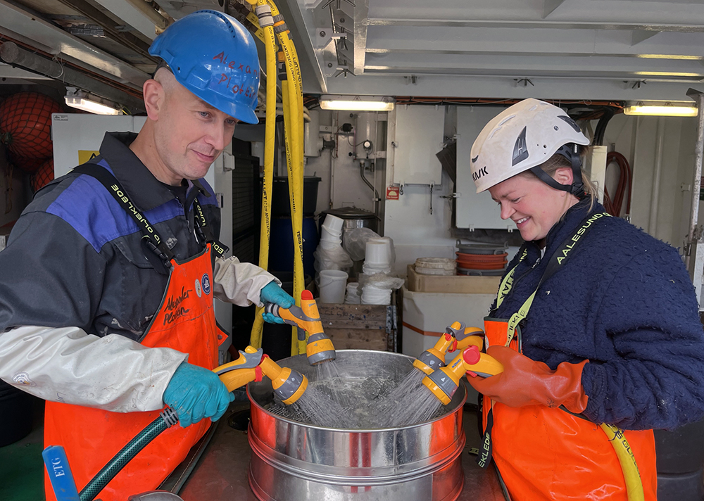 Alexander Plotkin and Marte Strømme sieving a grab sample through a coarse and a fine meshed sieve.