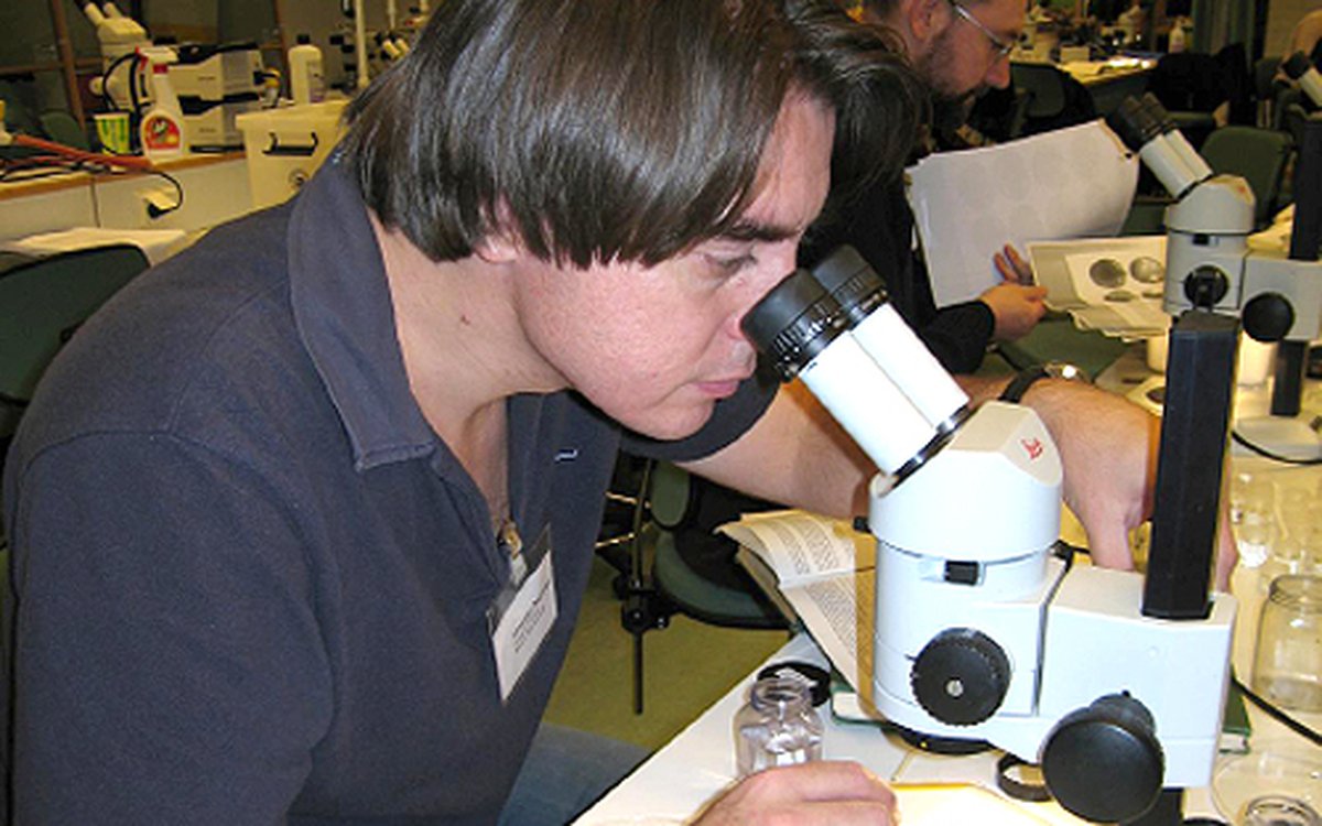 foto av mann som ser i mikroskop